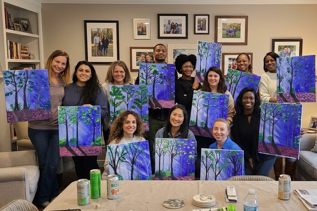 Friends displaying their purple forest paintings after painting together