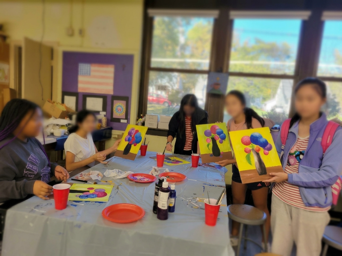 Young party guests holding their colorful paintings